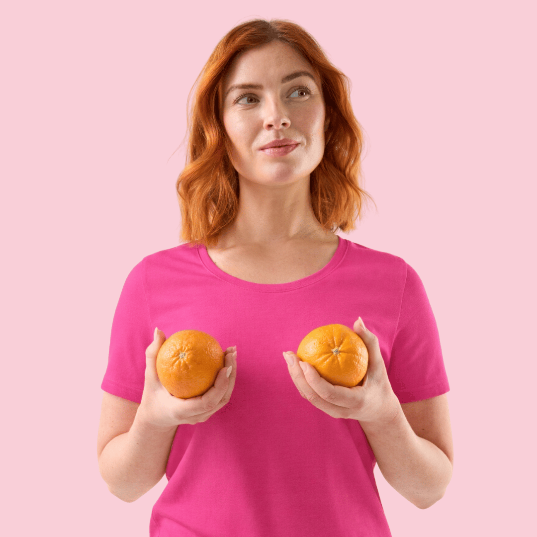 Rosa bild med kvinna iklädd rosa tröja hållandes två apelsiner