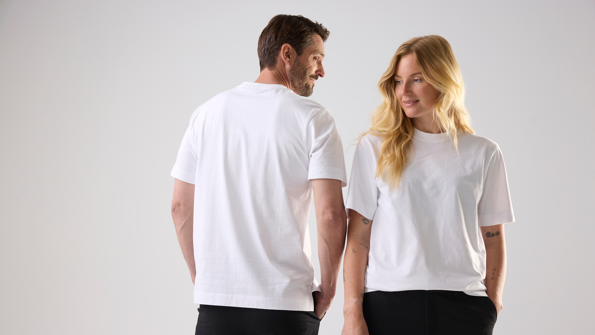 Två modeller iklädda vita t-shirts