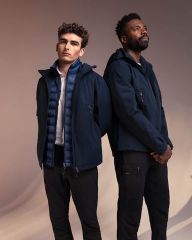 Two men in matching outerwear from South West – dark blue jackets with warming layers underneath, perfect for changing weather.