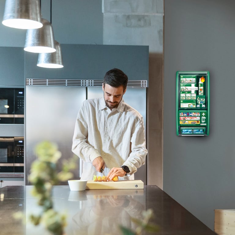 Man in lunchruimte op kantoor met EHBO-post aan de muur