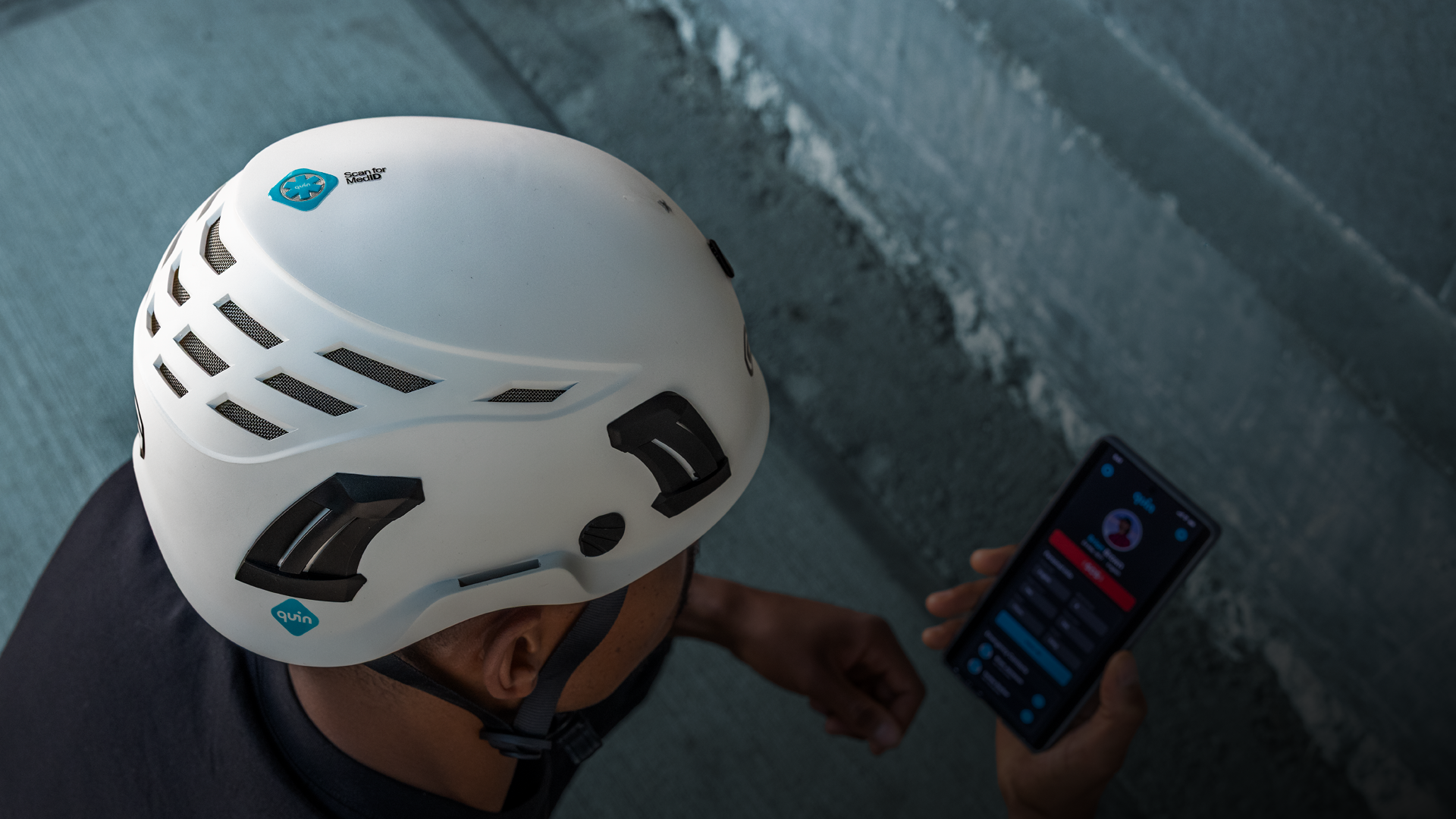 En bils som visar en man med en vit skyddshjälm med Quin logga