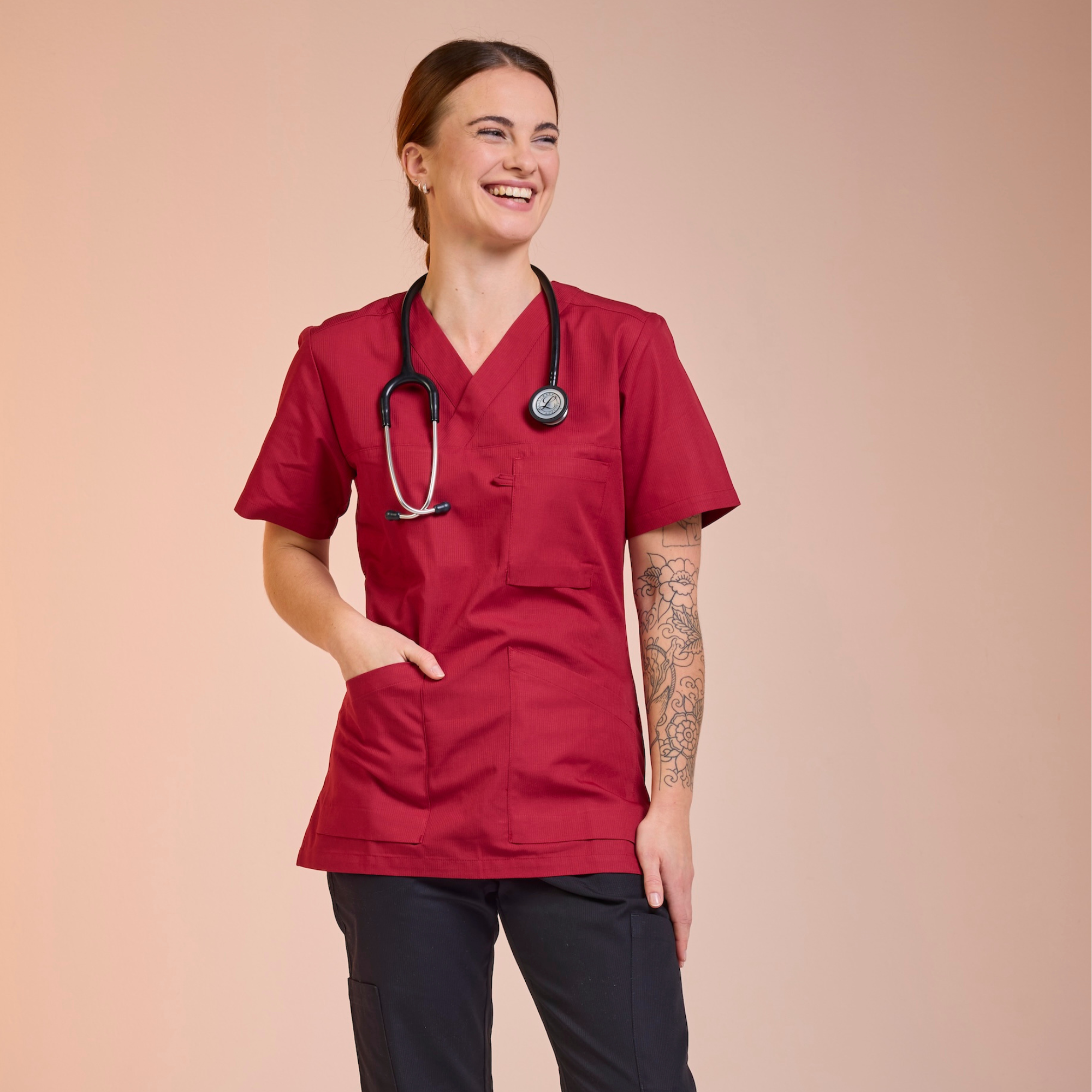 Frau in roter Pflegetunika aus dem South West – Arbeitskleidung mit hoher Qualität und zertifizierter Langlebigkeit.